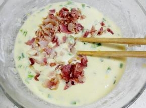 将培根碎加入鸡蛋糊中，拌匀