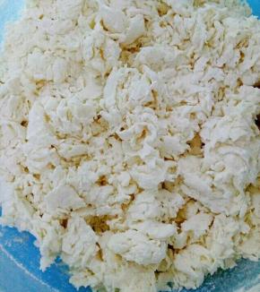 面粉放在盆里，一点一点的加温水，用筷子搅拌成如图的样子