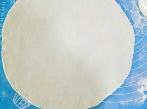 取一个剂子，下面撒少许干面粉，赶成薄薄的的圆皮