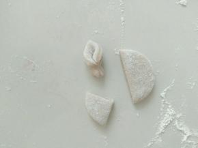 做猪耳朵，一圆切四半，取其中一半，对折。