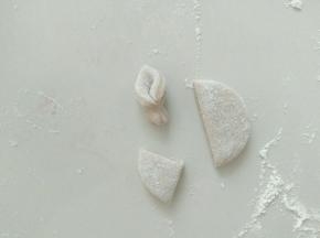 做猪耳朵，一圆切四半，取其中一半，对折。