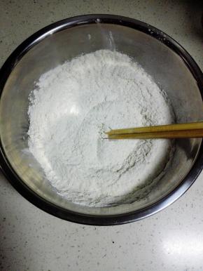 中粉放入盆中，加入酵母，用筷子搅匀