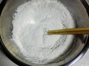 中粉放入盆中，加入酵母，用筷子搅匀