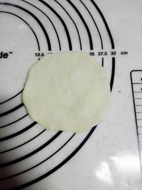 取一个面团，揉圆后压扁（可用擀面杖）