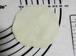 取一个面团，揉圆后压扁（可用擀面杖）