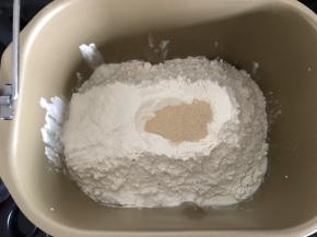 将主面团材料除黄油外按由湿到干的顺序加入和面桶，启动一个揉面程序。