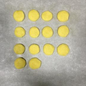 把面团分为每一个5g左右，揉圆按扁，放入铺了油纸的烤盘内