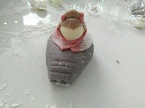 放进窝窝里，并用红色面团，做披风。黑色面团做头发。