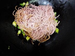 放入沥好的面条，加0.5茶匙盐，转中火，不停的翻炒，以免粘锅