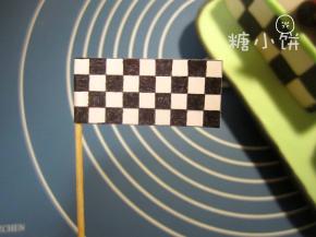 用纸画一面小旗子，就是画格子嘛没啥好说的。画好的格子纸剪下来对折粘合，牙签作为旗杆。