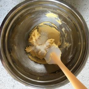 用刮刀翻拌均匀至无干面粉，然后倒入椰蓉，翻拌均匀