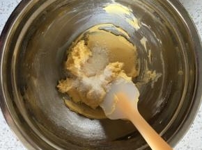 用刮刀翻拌均匀至无干面粉，然后倒入椰蓉，翻拌均匀