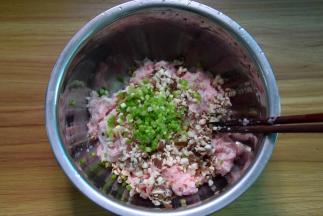 肉馅放盘中，加入切碎抓去水分的香菇和葱末