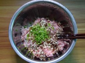 肉馅放盘中，加入切碎抓去水分的香菇和葱末