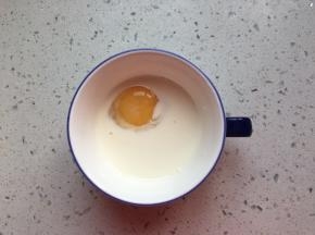 鸡蛋打入碗中，倒入牛奶