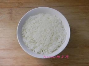 取蒸好的米饭放入小碗里压实成型；