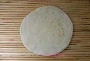 将圆锥面团竖立后，按扁，擀成1公分厚的面饼，放在盖帘上醒发30分钟；