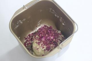 放入面包机稍微搅拌和面，很多方子是用手拌的。我的是按照自己想着做的。我是用面包机搅拌和面10分钟。再加入弄碎的玫瑰花的花瓣。再和面5分钟。