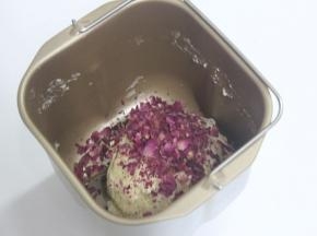放入面包机稍微搅拌和面，很多方子是用手拌的。我的是按照自己想着做的。我是用面包机搅拌和面10分钟。再加入弄碎的玫瑰花的花瓣。再和面5分钟。