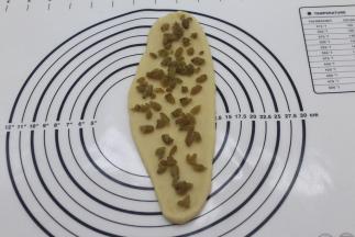 取面团擀舌形撒上葡萄干碎，（面团总共分成了三份的）