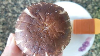 香菇内外侧刷上薄薄的玉米油，抹上适量盐，不要太多了