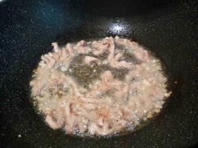 锅里油稍微多一点，爆香蒜泥，放肉丝翻炒变色
