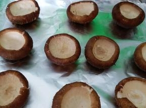 烤盘内铺锡纸，处理好的香菇挨个摆入烤盘，烤箱200度预热
