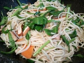 最后加入面条翻炒，用2双筷子不停地翻炒，让水分蒸发，再加入空心菜翻炒，