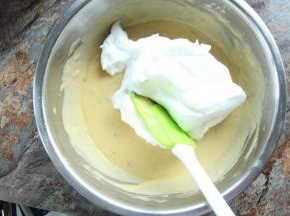 将三分之一的蛋白放入蛋黄糊中，从底部捞起翻拌匀，搅拌好的面糊全部倒入蛋白中，快速翻拌和切拌。