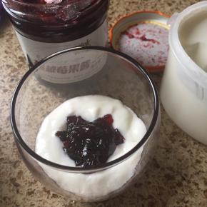 先在杯子里，放入一勺酸奶；再放入一勺果酱；