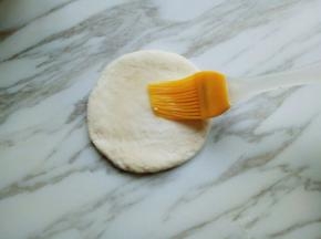 擀好的面片，用刷子刷上一层玉米油。