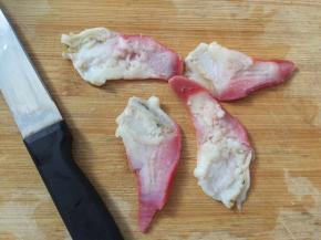 北极贝用小刀切半，用清水清洗里面的脏物