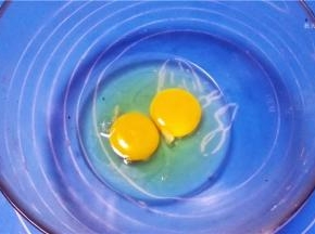 鸡蛋磕入容器内
