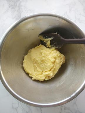 把低筋面粉筛入打发好的黄油里，用刮刀拌匀，成为湿软的面团。