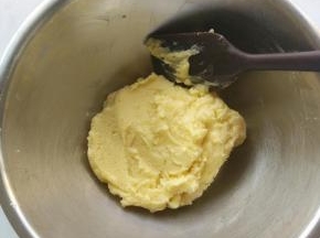 把低筋面粉筛入打发好的黄油里，用刮刀拌匀，成为湿软的面团。