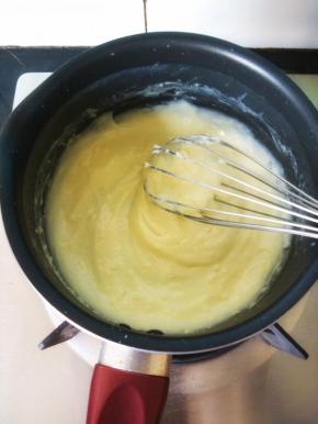 把温热的牛奶加入搅拌盆中混合均匀，再过滤倒回锅中。小火加热，并不停搅拌，使奶油浓稠且富有光泽。