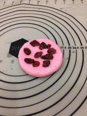 拿个红色面团按扁，放上蔓越莓