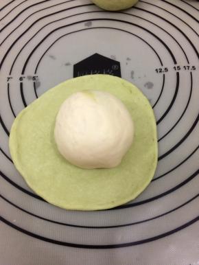 放上包好的白色面团收口朝下包好