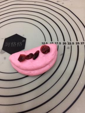 在上面放入少许的蔓越莓，包好滚圆，收口朝下放置