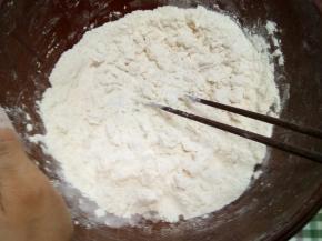 开水倒入面粉中，先用筷子搅拌成絮状