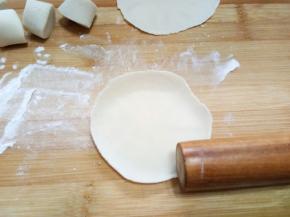 开始做剂子，案板上撒淀粉防粘。先弄成和饺子皮一样大小的剂子，擀成面皮，要比饺子皮薄一点，所以最后皮是比饺子皮大的。然后重点来了（敲黑板）把擀面杖放在图中位置，另一个手抻着面皮，就这样转圈擀压面皮一到二厘米的边缘。不知道这么形容能不能看懂。