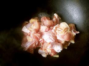 把鸡块儿倒入炒锅中开火翻炒，这一步不用油，炒的目的是把鸡腿中的血水逼出来，倒掉不要。