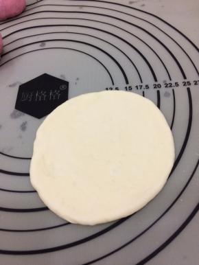 在拿个白色面团用手按扁