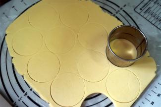 用圆形饼干模具压制饼干胚，并将饼干胚转移到烤盘上。