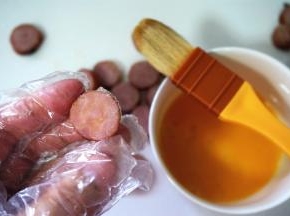 在香肠片的其中一面刷上一层全蛋液。