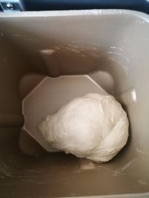 按下层液体，中层粉体，盐和糖放两角上，上层酵母埋入面粉中的顺序，开始揉面。