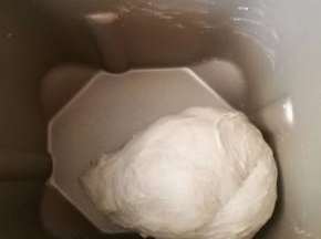 按下层液体，中层粉体，盐和糖放两角上，上层酵母埋入面粉中的顺序，开始揉面。