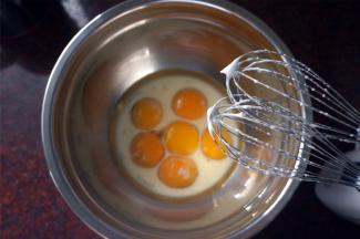 制作面糊：蛋黄中加入26克细砂糖，40克纯牛奶或清水，66克玉米油，拌至糖融化。