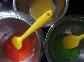 将蛋黄糊平均分成3分，其中两份分别滴入红色素和绿色素，拌均匀。