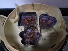 蒸笼内垫油纸或屉布，放上慕斯圈，先松松铺上一层粉类，然后放少许豆沙和蔓越莓干。没有慕斯圈，可以用其他小容器什么，如果是小蒸笼，也可以直接铺满整个蒸笼。